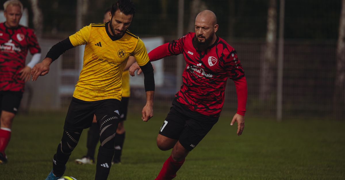 Players in action during a competitive soccer match wearing distinct team jerseys.